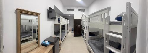 a room with several bunk beds and a mirror at Dubai Airport Hostel in Dubai