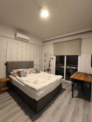 a bedroom with a bed and a table and a desk at Akman City Hotel in Kusadası