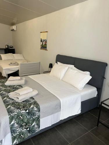 a bedroom with two beds with white sheets and pillows at Egee Guest House in Néa Péramos