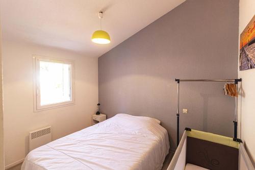 une petite chambre avec un lit dans le coin dans l'établissement Appart 3 pièces, à Capbreton