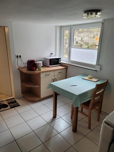 a small kitchen with a table and a microwave at Fereinwohnung mit 5 Schlafzimmern in Schlitz