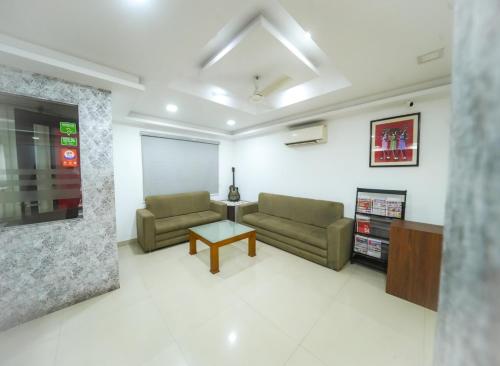 a living room with two couches and a table at Kay Pee's Grande in Cochin