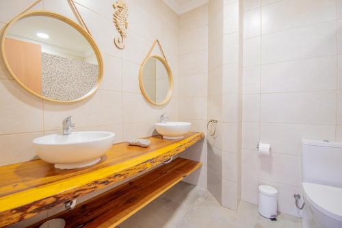 ein Badezimmer mit zwei Waschbecken und zwei Spiegeln in der Unterkunft Kizi Lovely apartment in Poço Partido