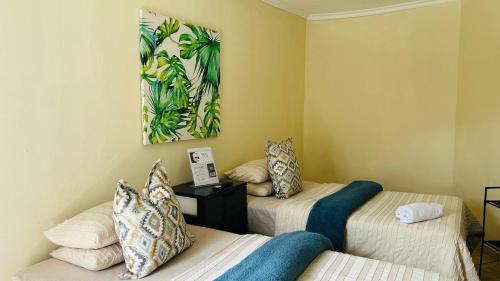 a room with two beds and a painting on the wall at AK Secunda Accommodation in Secunda