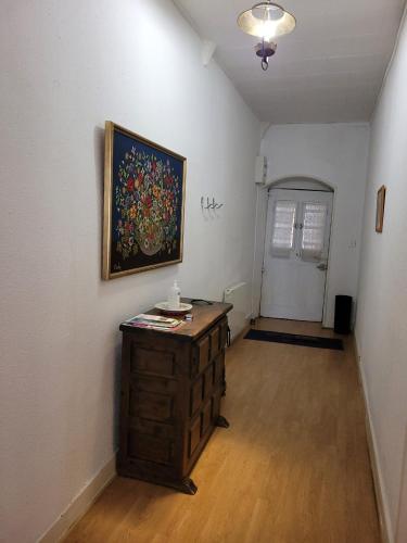 une chambre avec un tableau sur le mur et une commode en bois dans l'établissement Hébergement Flotiane, à Belley