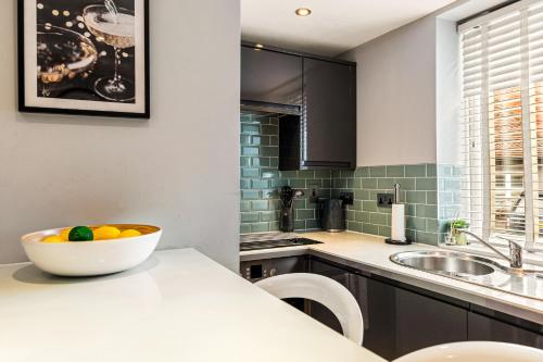 a kitchen with a bowl of fruit on a counter at River cabin & Mills Cottage in Henley on Thames