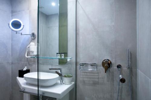 a bathroom with a sink and a glass shower at Wyndham Athens Residence in Athens