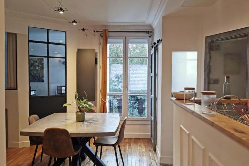 une cuisine et une salle à manger avec une table et des chaises dans l'établissement T2 apartment in the heart of Père Lachaise, à Paris