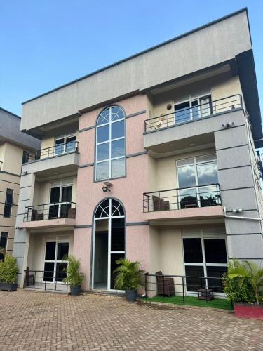a building with windows and plants in front of it at KOSUHOMEs in Namugongo