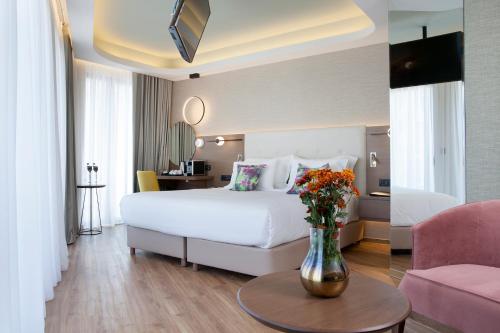 a hotel room with a bed and a vase of flowers at Wyndham Athens Residence in Athens