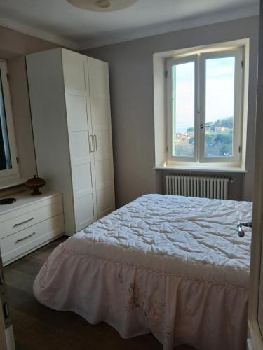a bedroom with a bed and a dresser and two windows at Casa Misha tra 5 Terre e Versilia in Bocca di Magra