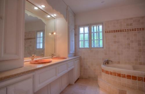 une salle de bain avec deux lavabos, une baignoire et un miroir dans l'établissement Villa Martine, authentic family home, à Rognes