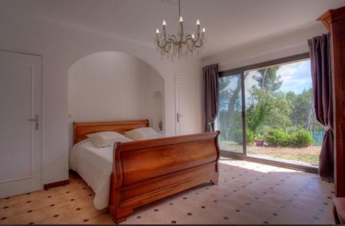 une chambre avec un lit et une grande fenêtre dans l'établissement Villa Martine, authentic family home, à Rognes