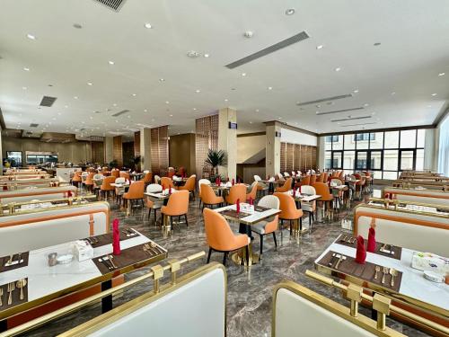 un ristorante con tavoli e sedie in una stanza di Gold Phuc Resort inside Longvien Golf a Vientiane