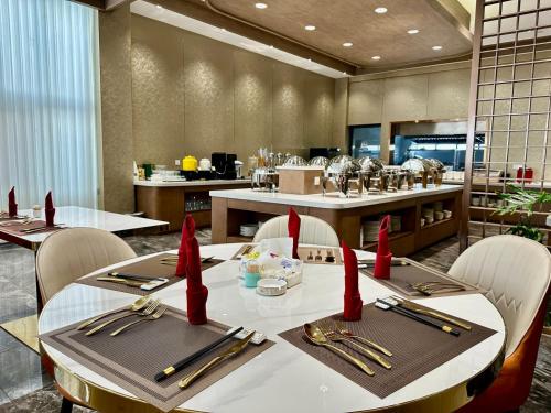 un ristorante con un tavolo e sedie con tovaglioli rossi di Gold Phuc Resort inside Longvien Golf a Vientiane