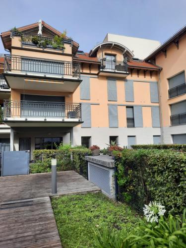 un immeuble d'appartements avec une passerelle en bois devant lui dans l'établissement Appartement 67 m2 avec 100 m2 jardin privatif RESERVABLE UNIQUEMENT PAR PERIODE DE 7 JOURS MINIMUM DU SAMEDI AU SAMEDI, à Arcachon