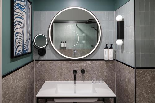 a bathroom with a sink and a mirror at voco Fareham - Solent by IHG in Fareham