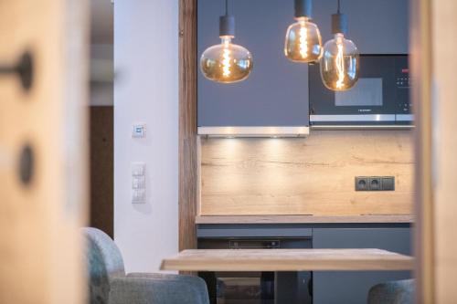 a kitchen with a table and a microwave and lights at Apartments Hochbrunn - Pension Brunner in San Giuseppe in Anterselva
