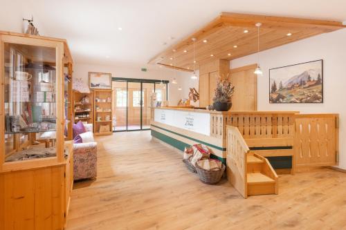 a living room with wooden floors and a room with wooden walls at Narzissendorf Zloam Hotel in Grundlsee