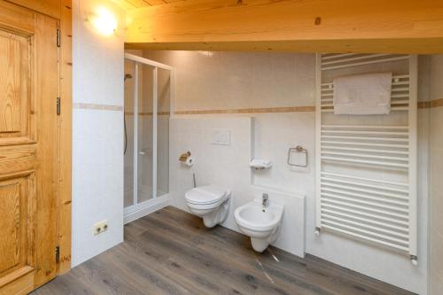 a bathroom with a toilet and a shower at Hotel Garni Le Corti in Grosotto