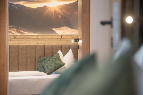 a bedroom with a bed with a picture of a mountain at Apartments Hochbrunn - Pension Brunner in San Giuseppe in Anterselva