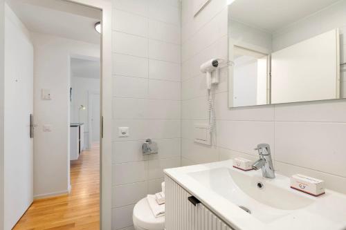a white bathroom with a sink and a mirror at Novos Contrada in Lugano
