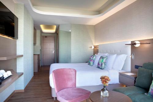 a hotel room with a bed and a chair at Wyndham Athens Residence in Athens