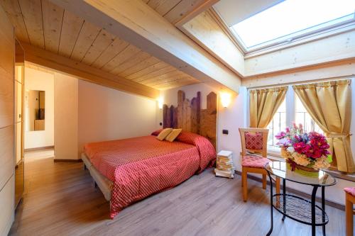 a bedroom with a large bed and a skylight at Hotel Garni Le Corti in Grosotto