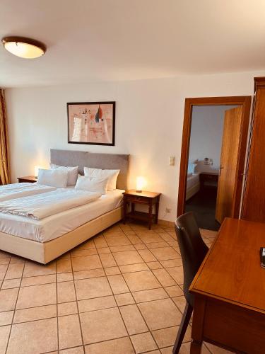 a bedroom with a bed and a table and a desk at Hotel am Luisenplatz in Potsdam