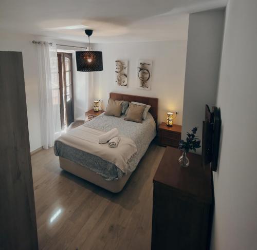 a bedroom with a large bed and a window at Alojamiento Wadi Dar Al-Farah "La Casa de la Alegría de Guadix" in Guadix