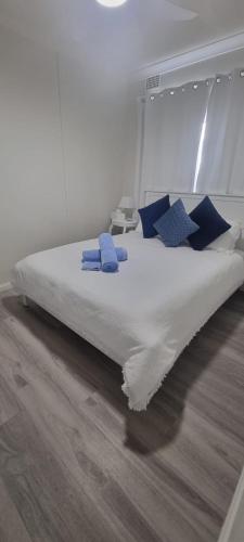 a bed with blue pillows on it in a room at 2 x Bedroom Deluxe Hampton Apartment in Shoal Bay