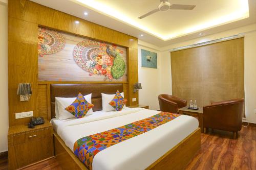 a hotel room with a bed and a painting on the wall at FabHotel Prime Star 17 - Nr Yashobhoomi Convention Centre in New Delhi