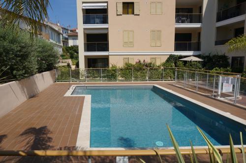 une piscine devant un immeuble dans l'établissement Palm beach apartment with swimming pool in a residence, à Cannes