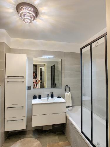 une salle de bain avec un lavabo, une douche et une baignoire dans l'établissement Palm beach apartment with swimming pool in a residence, à Cannes