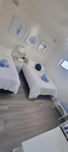 a bedroom with two beds and pictures on the wall at 2 x Bedroom Deluxe Hampton Apartment in Shoal Bay