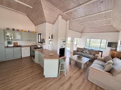 sala de estar amplia con sofá y cocina en 120 on Lyme, en St Francis Bay