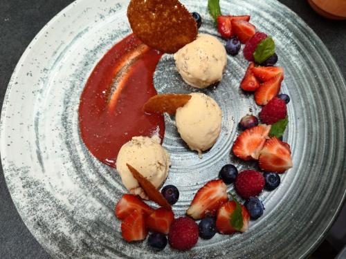 a plate with ice cream and fruit on it at Landgasthof Detsch in Haig