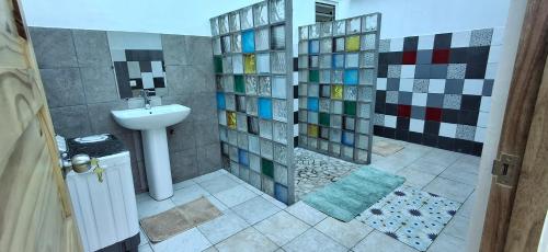 Un baño con ducha, lavabo e inodoro. en Camping Nany, en Taputapuapea