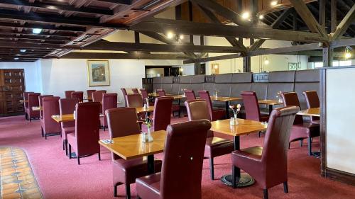 a dining room with wooden tables and chairs at Europa Gatwick Hotel & Spa in Crawley