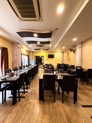 a restaurant with tables and chairs in a room at Hotel Royal Palm - A Budget Hotel in Udaipur in Udaipur