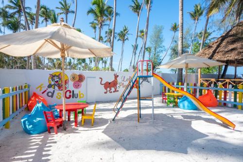 a playground with a slide and an umbrella at Royal Mandarin Hotel & Resort in Pwani Mchangani