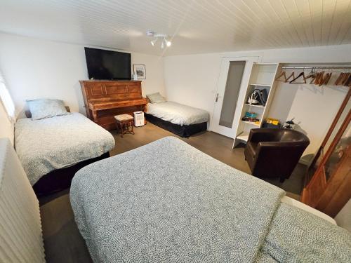 サン・ブリューにあるMaison spacieuse avec jardin et salle de sportのリビングルーム(ベッド2台、ピアノ付)