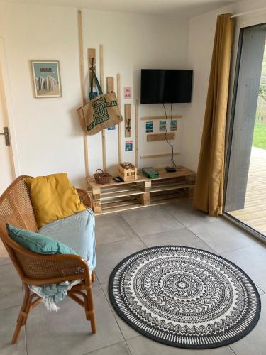 un salon avec une chaise et une télévision dans l'établissement Eco-friendly house, à Saint-Nic