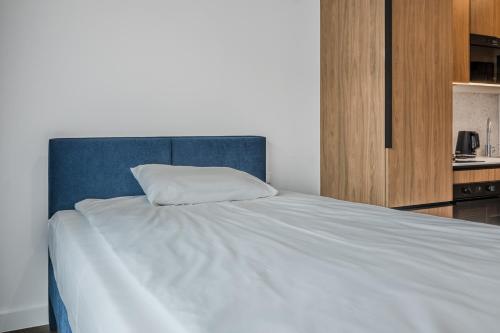 a bed with a blue headboard and a white pillow at Noli Gdansk Wrzeszcz in Gdańsk