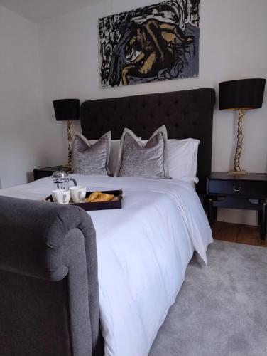 a bedroom with a large white bed and two lamps at Spacious Family Cottage Retreat in North Perrott