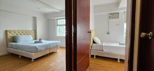 a small bedroom with a bed and a window at Gilmore Tower Suites By SMS Hospitality in Quezon City