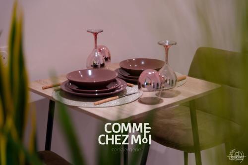 une table avec des assiettes et des verres à vin dessus dans l'établissement Suite Le Cocon & Spa, à Nancy