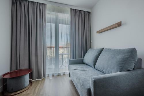 a living room with a couch and a large window at Noli Gdansk Wrzeszcz in Gdańsk