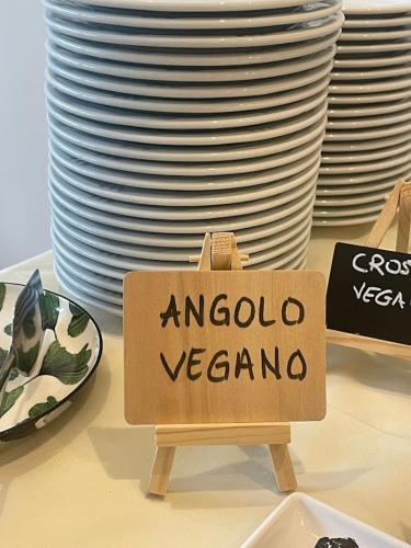 a sign that says argento vegan on a table with plates at Aura Living Hotel in Rimini