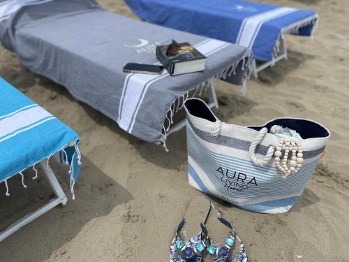 a pair of beds and a pair of shoes on the beach at Aura Living Hotel in Rimini